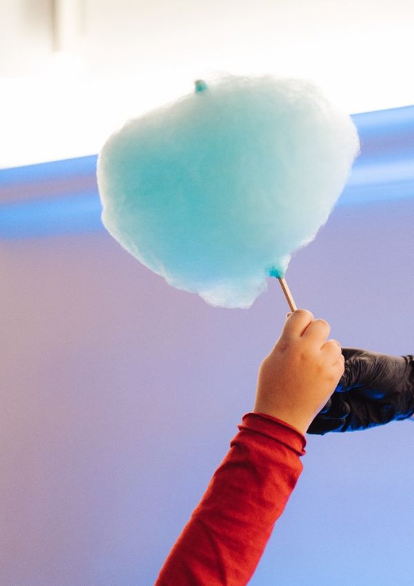 Zucchero filato azzurro tenuto da una mano di bambino
