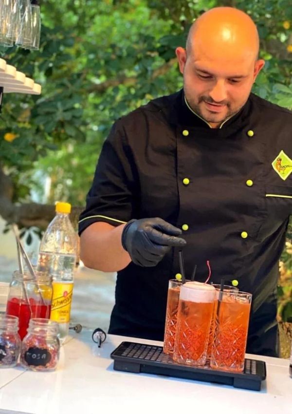 Il barman di Kokopelli prepara due cocktail con ghiaccio e frutta